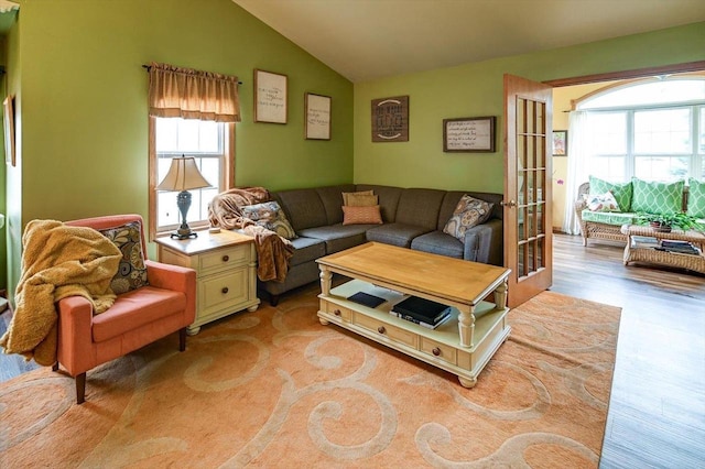 living room featuring plenty of natural light, light wood finished floors, and vaulted ceiling