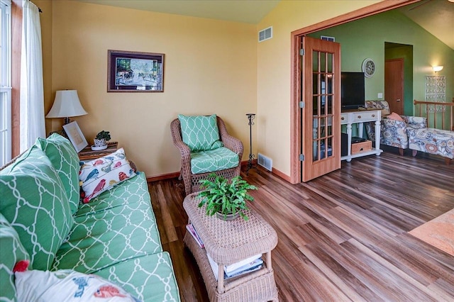 living room with visible vents, baseboards, and wood finished floors