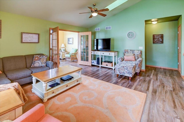 living room with french doors, a ceiling fan, visible vents, vaulted ceiling, and wood finished floors