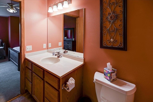 half bath with vanity, ceiling fan, and toilet