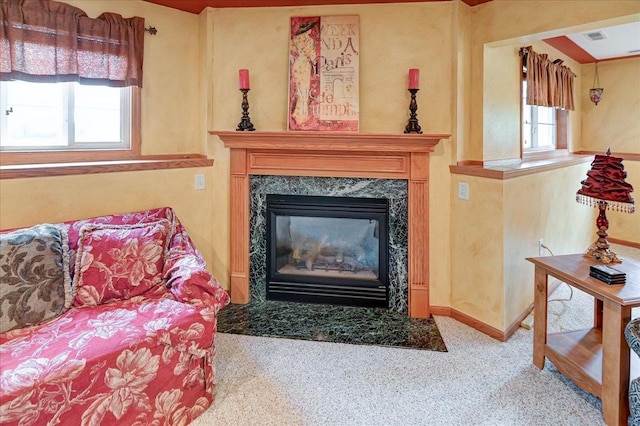 living area with a fireplace, baseboards, carpet, and visible vents
