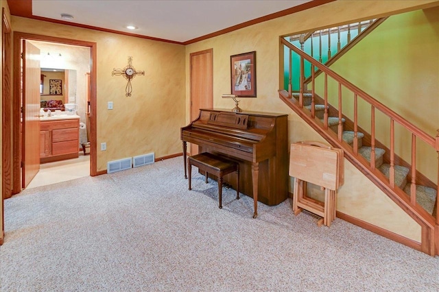 sitting room with carpet flooring, visible vents, ornamental molding, and stairway