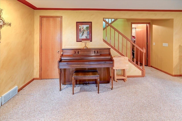 living area with carpet flooring, crown molding, baseboards, visible vents, and stairway