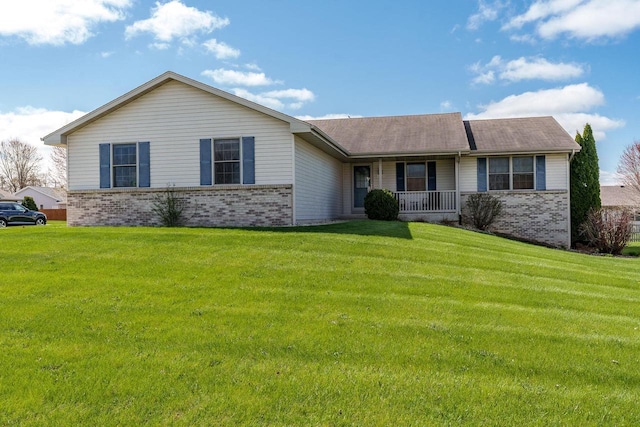 ranch-style house featuring brick siding, a front yard, and a porch