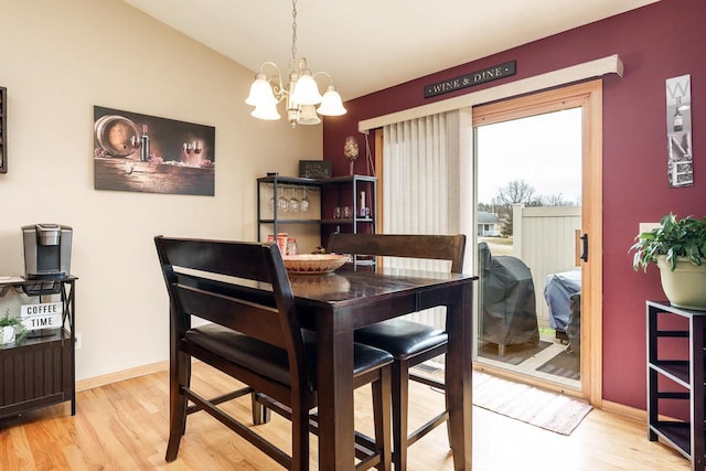 dining area featuring an inviting chandelier, baseboards, and wood finished floors