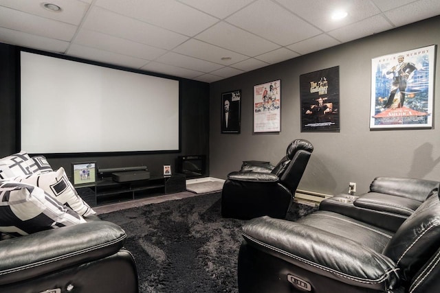 carpeted cinema room featuring baseboards and a drop ceiling