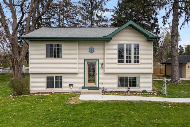 bi-level home featuring entry steps and a front lawn