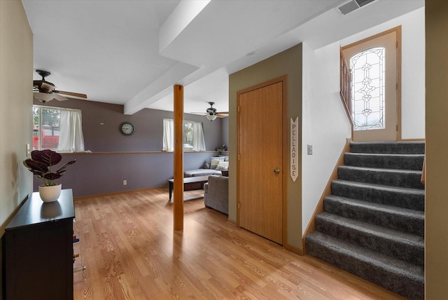 interior space featuring stairs, a ceiling fan, visible vents, and light wood finished floors