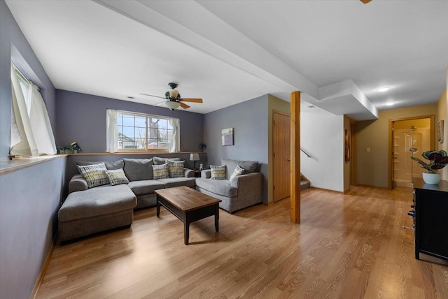 living area featuring stairway, ceiling fan, and light wood-style floors