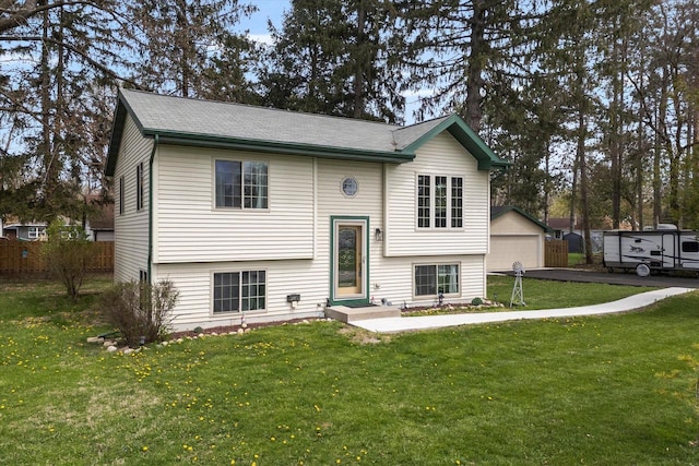 view of front of home featuring a detached garage, an outbuilding, and a front yard