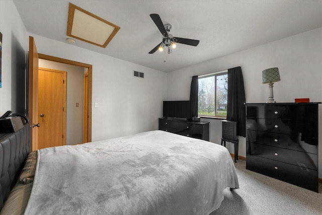 bedroom featuring visible vents, attic access, carpet floors, and a ceiling fan