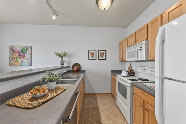 kitchen with dark countertops, light tile patterned floors, baseboards, a sink, and white appliances