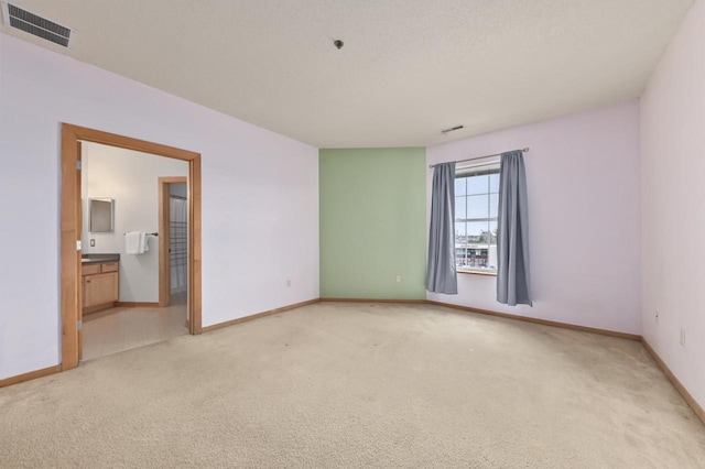 unfurnished room featuring visible vents, baseboards, and light carpet