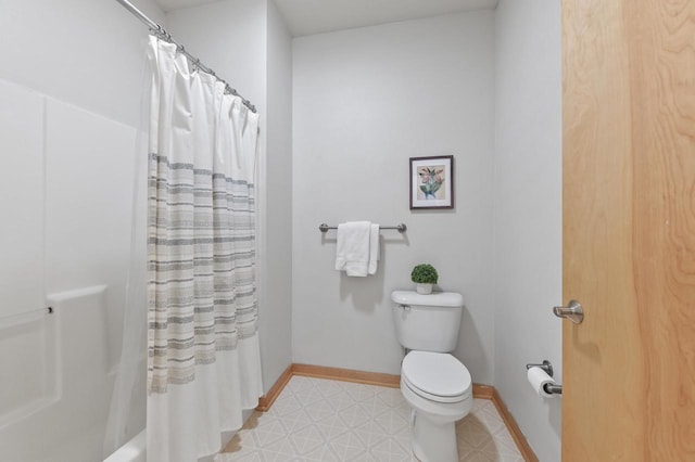 bathroom featuring baseboards, a shower with shower curtain, tile patterned floors, and toilet