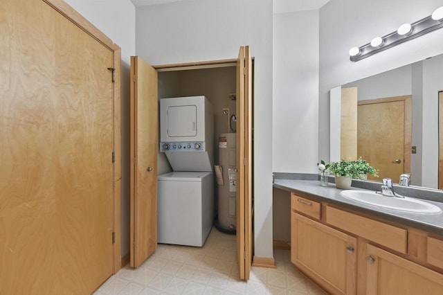 bathroom featuring stacked washer and dryer, vanity, toilet, tile patterned floors, and electric water heater
