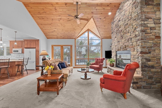 living area with high vaulted ceiling, plenty of natural light, and wood ceiling