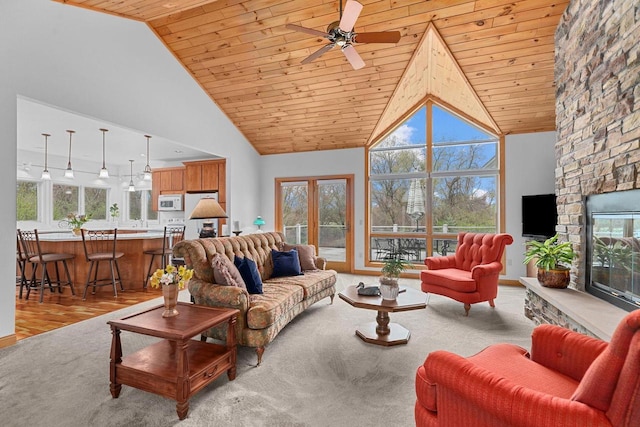 living room with a healthy amount of sunlight, wooden ceiling, and a ceiling fan