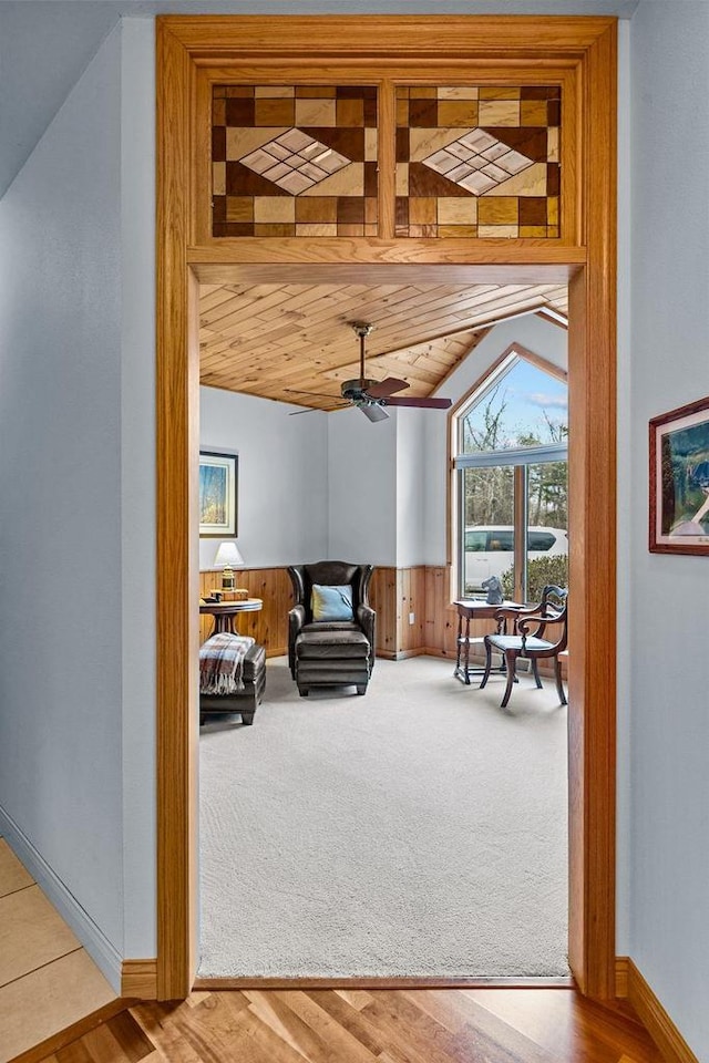 carpeted living room featuring a ceiling fan, baseboards, vaulted ceiling, and wooden ceiling