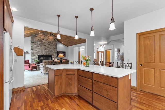 kitchen featuring open floor plan, wood finished floors, freestanding refrigerator, and light countertops