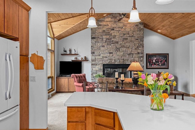 kitchen with brown cabinets, light countertops, freestanding refrigerator, lofted ceiling, and wood ceiling