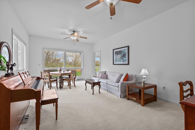 living area with ceiling fan and light colored carpet