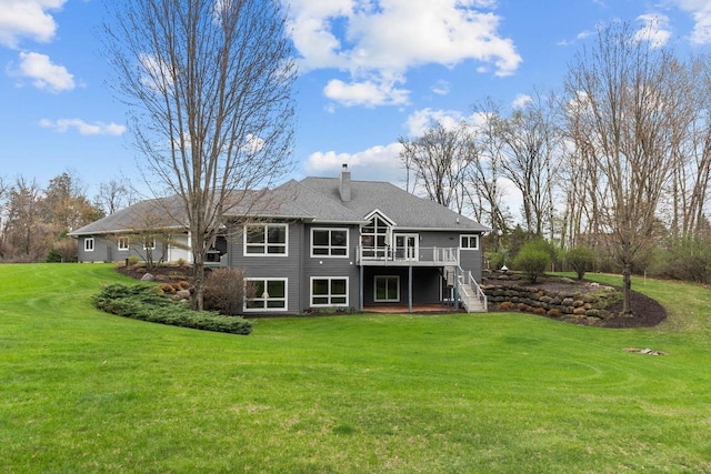 rear view of house featuring a lawn, stairway, a chimney, and a deck