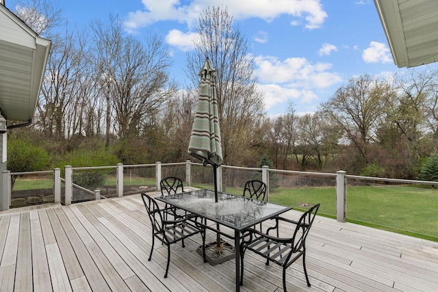 wooden deck with a lawn and outdoor dining area