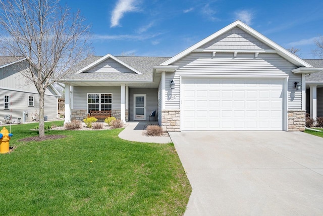 craftsman-style home with a garage, a front lawn, and stone siding