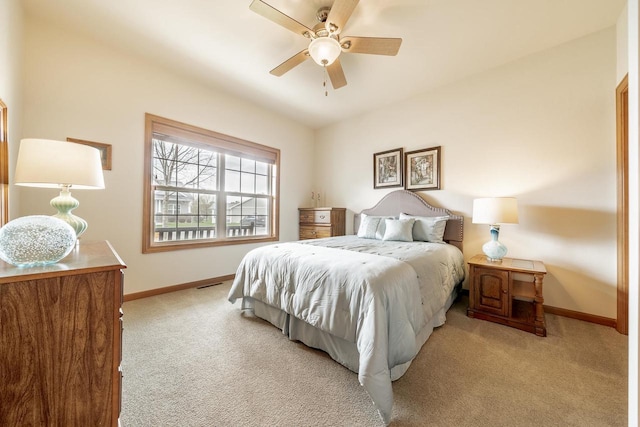 bedroom with a ceiling fan, baseboards, and light carpet
