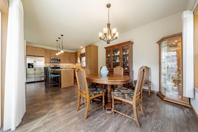 dining space featuring baseboards, an inviting chandelier, a healthy amount of sunlight, and dark wood finished floors
