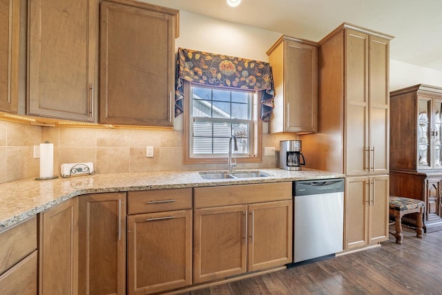 kitchen featuring light stone counters, a sink, dark wood finished floors, tasteful backsplash, and stainless steel dishwasher