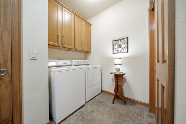 washroom featuring separate washer and dryer, baseboards, and cabinet space