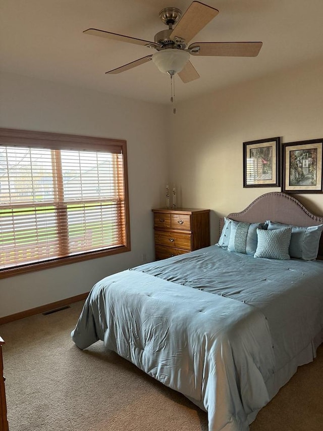 bedroom featuring carpet flooring, baseboards, visible vents, and ceiling fan