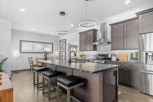 6667 S Chickahauk Trl, Middleton, WI 53562 - kitchen with a sink, wall chimney exhaust hood, stainless steel fridge, dark countertops, and stove