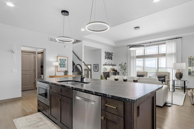 6667 S Chickahauk Trl, Middleton, WI 53562 - kitchen with appliances with stainless steel finishes, a sink, dark brown cabinetry, light wood-type flooring, and recessed lighting