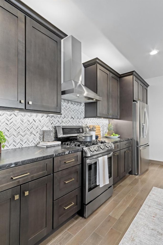 6667 S Chickahauk Trl, Middleton, WI 53562 - kitchen featuring appliances with stainless steel finishes, wall chimney exhaust hood, light wood-type flooring, dark brown cabinets, and decorative backsplash