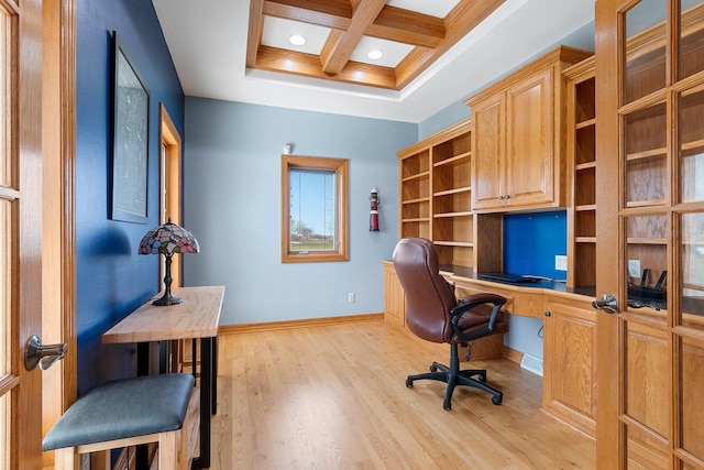 office space featuring beam ceiling, built in desk, light wood finished floors, baseboards, and coffered ceiling