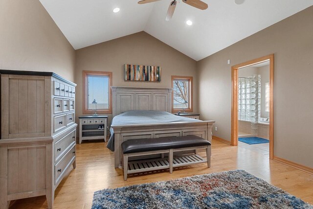 bedroom featuring baseboards, ensuite bathroom, light wood-style flooring, and lofted ceiling