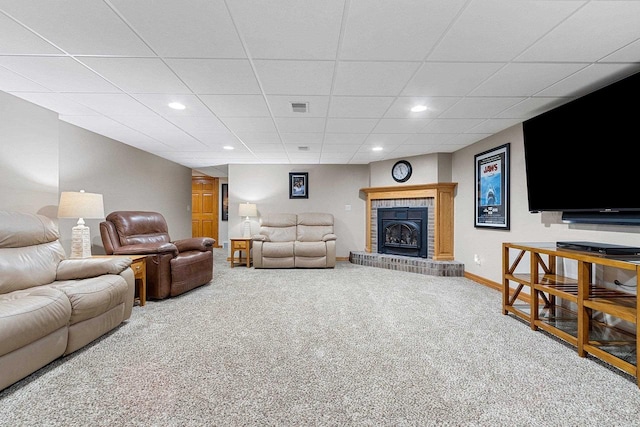 carpeted living area featuring visible vents, a brick fireplace, baseboards, a drop ceiling, and recessed lighting