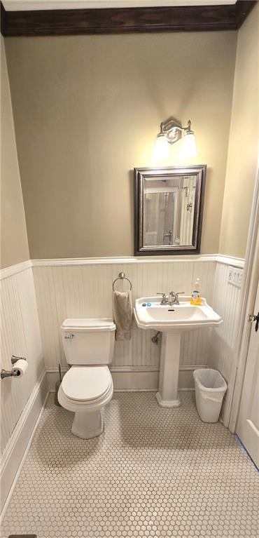 422 W Columbia St, Chippewa Falls, WI 54729 - bathroom featuring a wainscoted wall, tile patterned floors, and toilet