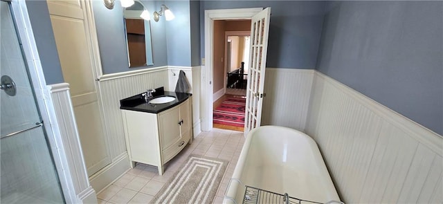 422 W Columbia St, Chippewa Falls, WI 54729 - bathroom featuring wainscoting, vanity, tile patterned floors, a bath, and a stall shower