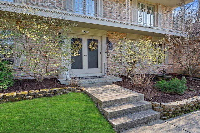 19425 Killarney Way, Brookfield, WI 53045 - view of exterior entry with a lawn, brick siding, french doors, and a balcony