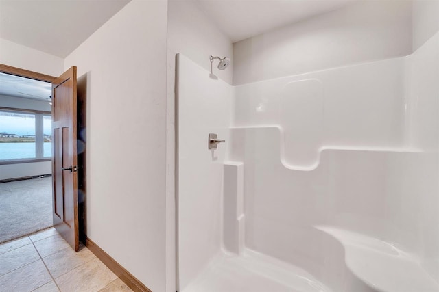 bathroom featuring baseboards, tile patterned flooring, and walk in shower