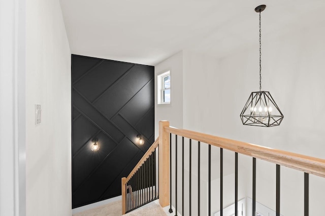 stairs with a chandelier and a decorative wall