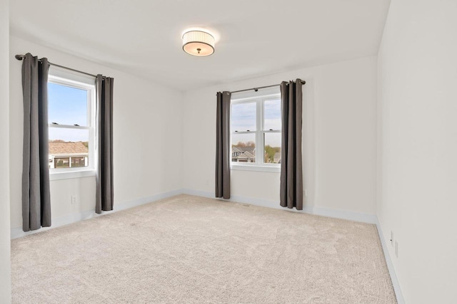 unfurnished room with carpet floors, plenty of natural light, and baseboards