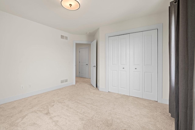 unfurnished bedroom with carpet floors, baseboards, and a closet