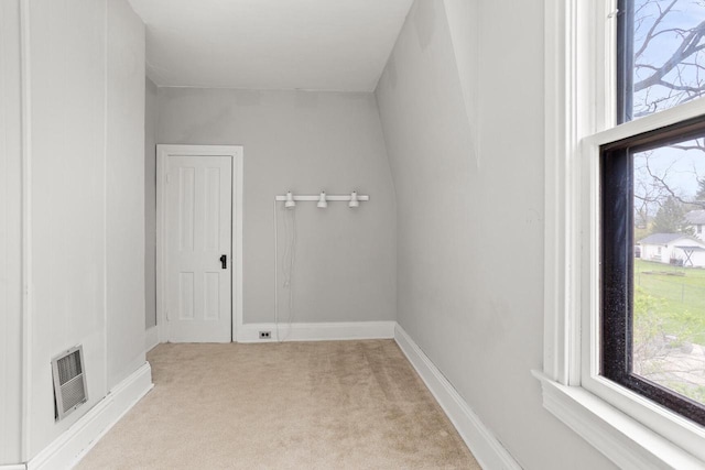 spare room with visible vents, baseboards, a wealth of natural light, and light colored carpet