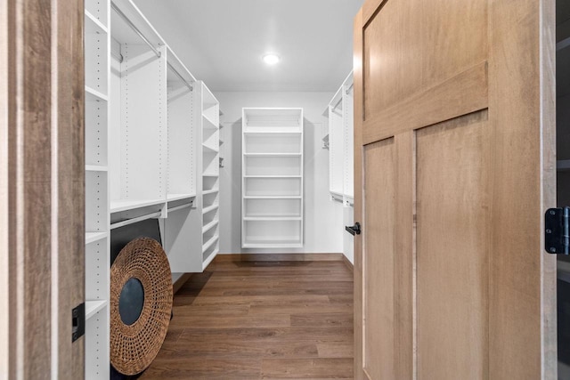 walk in closet with wood finished floors