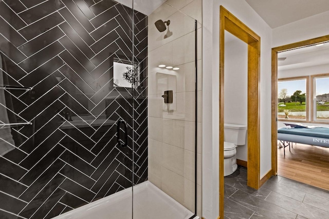 full bath with baseboards, a stall shower, and toilet