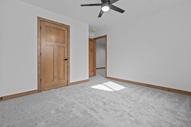 unfurnished bedroom featuring carpet floors, a ceiling fan, baseboards, and visible vents